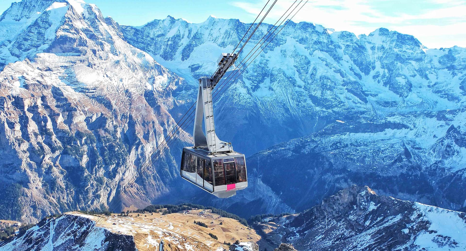 Cable car system above snowy mountain peaks