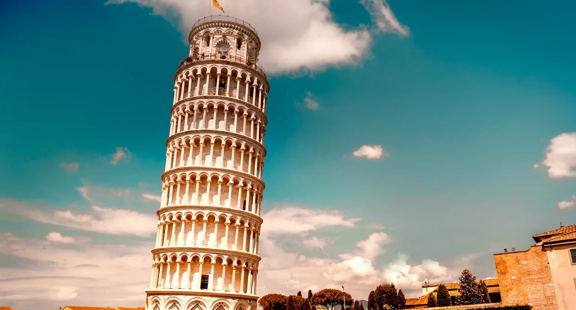 Leaning Tower of Pisa against a blue sky with clouds.